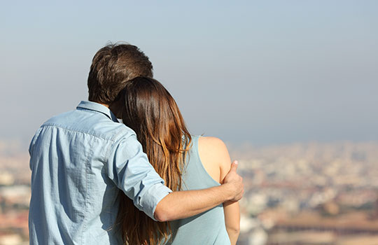 Pareja abrazada mirando el horizonte
